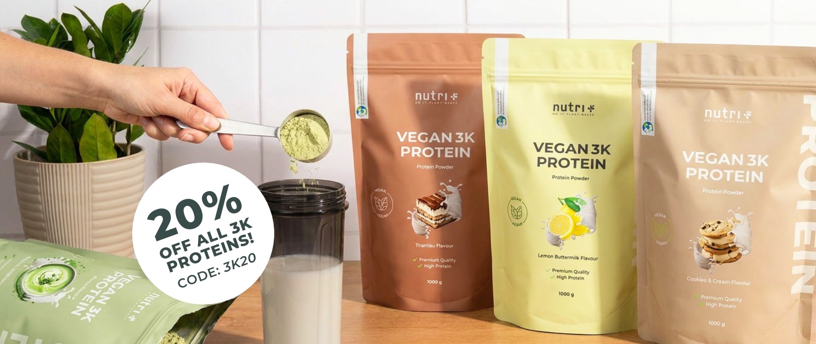 Various Vegan 3K Protein bags displayed with a shaker and a discount promotion sign.
